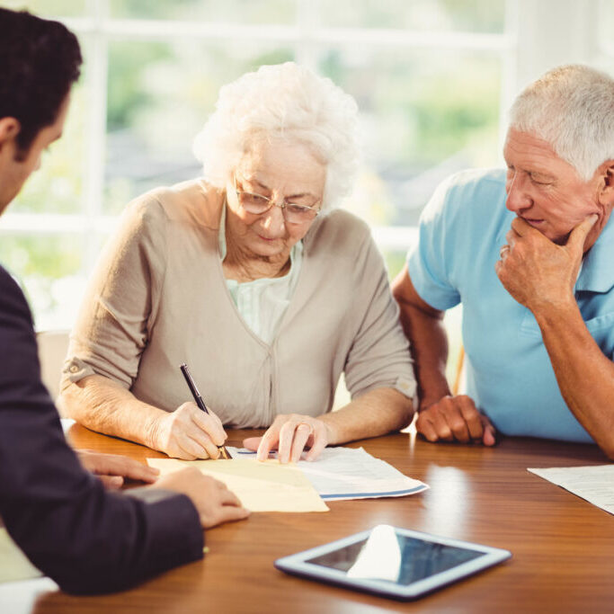 an old couple signing a document